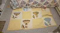 Both quilts shown: Dresden plate on bed, Sunbonnet Sue style on floor