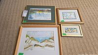 Group shot of all four framed prints laid out on carpet