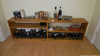 Front view of solid wood wine rack shelf with bottles and tins (contents not included)