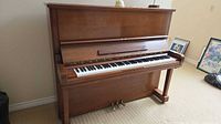 Front view of Steigerman upright piano with keyboard exposed