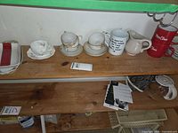 Shelf showing teacups, saucers, mugs, creamer