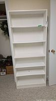 Front view of white bookcase showing shelves