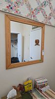 Front view of wood-framed mirror on wall