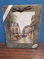 Full view of slate tile with mounted art print and leather hanger