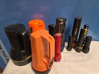Group of nine assorted flashlights displayed upright