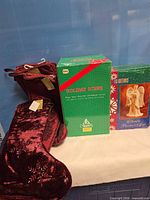 Group shot of velvet stockings beside two green holiday boxes