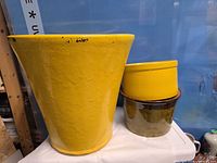 Three yellow ceramic planters side-by-side showing sizes