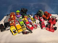 Full lot of approximately 30 mixed toy vehicles displayed on white surface
