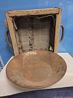 Steel gold pan in front of wooden screen