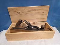 Hand plane placed in open pine box