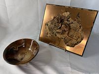 Plaque front and pottery bowl side by side