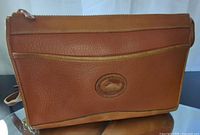 Front view showing pebbled leather, oval logo, front pocket