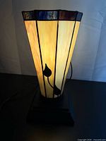 Lamp lit showing front panel with vine design and amber glow