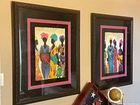 Both framed paintings hung on wall