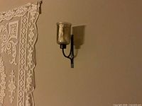 Left wall sconce showing bracket, glass shade, and candle