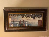 Front view of first art print showing figures on balcony in brown frame