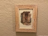 Print with open outhouse door in wood frame