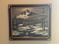 Framed winter mountain painting on wall