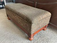 Full view of upholstered storage chest showing fabric top and wood base