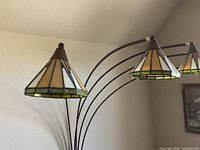 Close view of two stained glass cone shades and arm construction