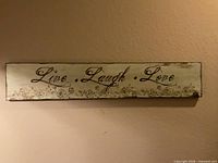 Full view of wooden wall sign showing text and floral motif