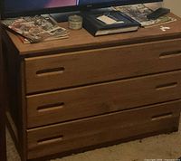 Front view of dresser showing three drawers and slot handles