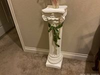 Full view of white column pedestal against wall