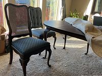 Dining table with two Queen Anne chairs in room
