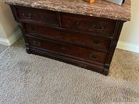 Front view of chest showing granite top, drawer arrangement and metal pulls