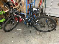 Full left side view of black and blue Supercycle Bear Mountain mountain bike