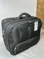 Front view showing overall design, front pocket, top handle, luggage tag