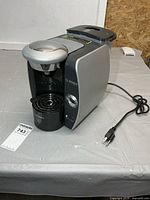 Front three-quarter view showing entire Bosch Tassimo coffee maker, power cord and drip tray