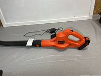 Full view of Black+Decker cordless leaf blower with charger cord visible
