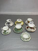 Group shot of six cup & saucer pairs plus condiment dish