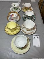 All seven teacup and saucer sets laid out