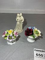 Group view: two porcelain floral arrangements in bowls and 5 in porcelain couple figurine with “50”