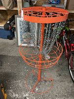 Assembled orange disc golf basket with chains and base