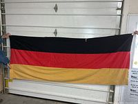 Full view of flag held horizontally showing tricolor design