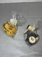 two tied plastic bags containing yellow and black rim coins