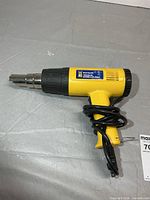 Full view of yellow Power Fist heat gun with cord wrapped around handle