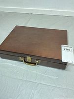 Closed wooden case showing exterior finish, latch and handle