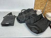 Overview of Danier satchel and two Lopez totes on table