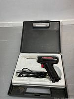 Overall view of soldering gun seated in carry case