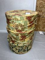 Stack of five patterned round boxes with rope handles