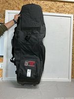 Full view of black collapsible travel golf bag on wheels