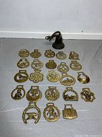All 23 brass horse brasses arranged plus small bell above