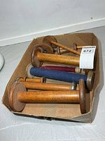 Top view of box showing various sizes of vintage wooden spools