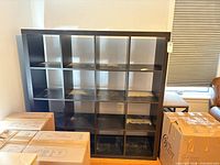 Front view of black 4 x 4 cube organizer showing 16 cubbies and overall wear