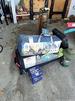 All items grouped: tent in blue bag, screenhouse in black bag, boxed Wiltro lantern, vintage green lantern, hard black case