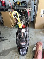 Full view of Nike plaid cart bag loaded with clubs, headcovers, umbrella
